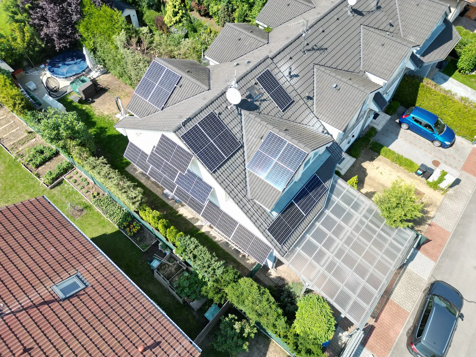 Letecký pohled na řadové domy s fotovoltaickými panely na několika střechách